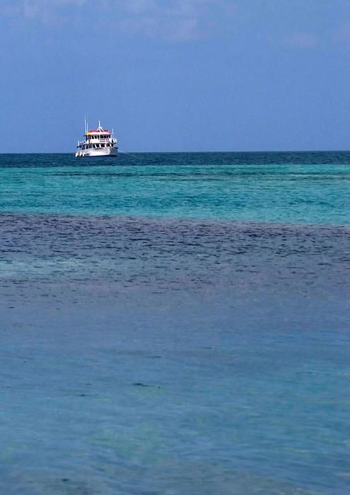 a boat anchored in the blue waters of the caribbean